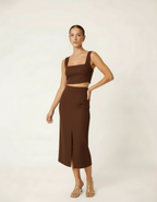 Modelo posando com conjunto cropped e saia midi marrom chocolate com fenda - Amarine