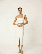 Modelo posando com conjunto cropped e saia midi off-white com fenda frontal - Amarine