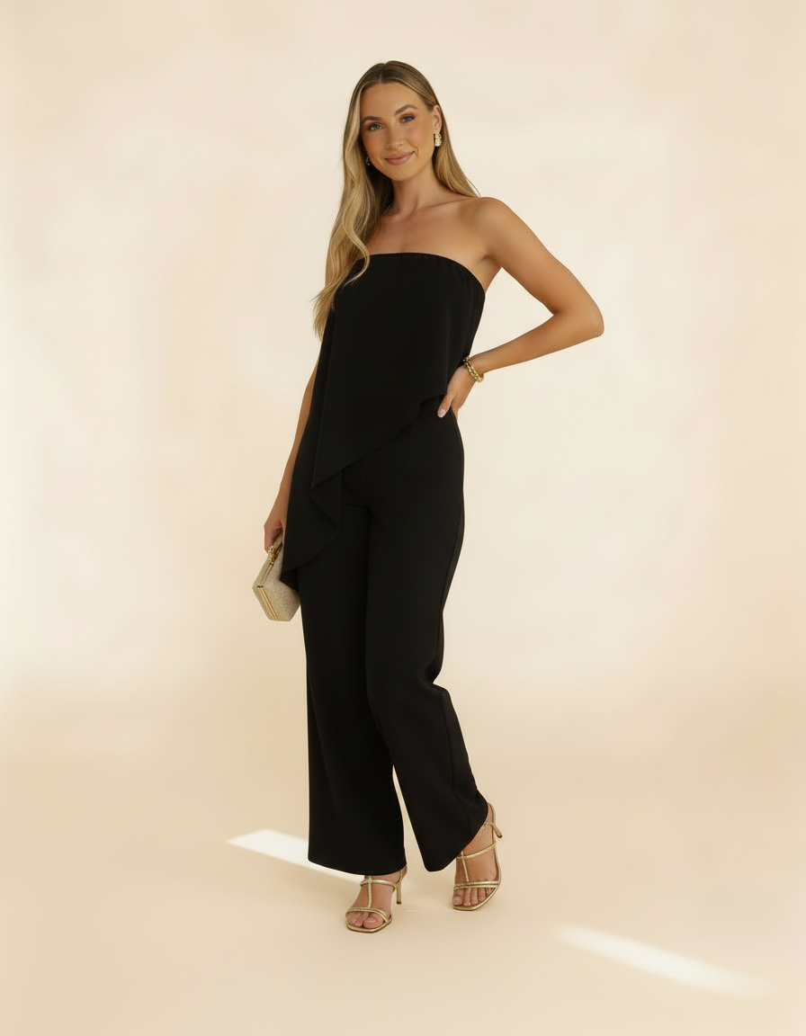 Modelo posando com macacão tomara-que-caia preto, segurando bolsa - Amarine