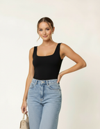 Modelo posando com regata preta gola quadrada, calça jeans clara e bolsa bege - Amarine