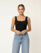 Modelo posando com regata preta gola quadrada e calça jeans wide leg, mãos cruzadas - Amarine