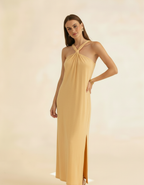 Modelo posando com vestido longo amarelo manteiga de gola halter com fenda lateral - Amarine