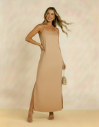 Modelo com vestido longo bege de alças finas e fenda lateral - Amarine