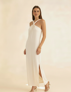 Modelo posando com vestido longo off-white de gola halter com fenda lateral - Amarine