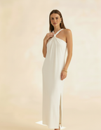 Modelo posando de frente com vestido longo off-white de gola halter com fenda lateral - Amarine
