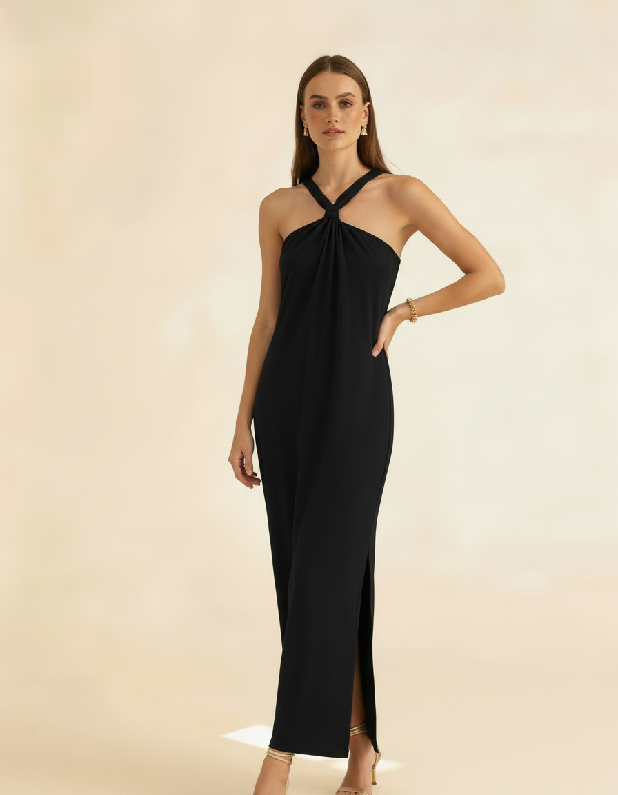 Modelo posando com vestido longo preto de gola halter, mão na cintura, vista frontal com fenda - Amarine