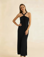 Modelo posando com vestido longo preto de gola halter, mãos na cintura com fenda lateral - Amarine