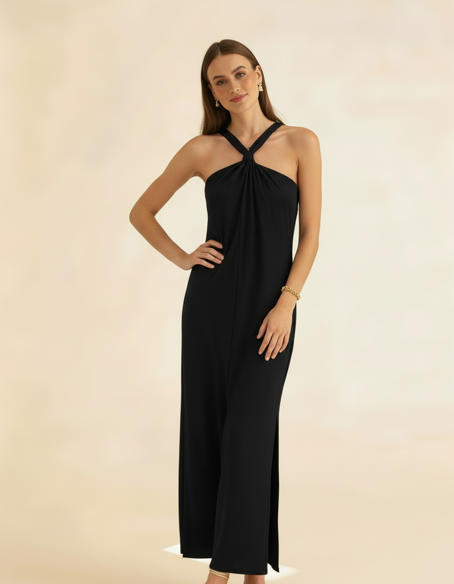 Modelo posando com vestido longo preto de gola halter, mãos na cintura com fenda lateral - Amarine