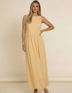 Modelo com pulseira dourada e mão na cintura usando vestido midi amarelo manteiga rodado sem mangas - Amarine