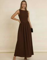 Modelo com mão na cintura e clutch preta usando vestido midi marrom rodado sem mangas - Amarine