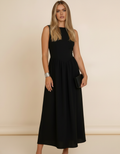 Modelo com clutch preta usando vestido midi preto rodado sem mangas - Amarine