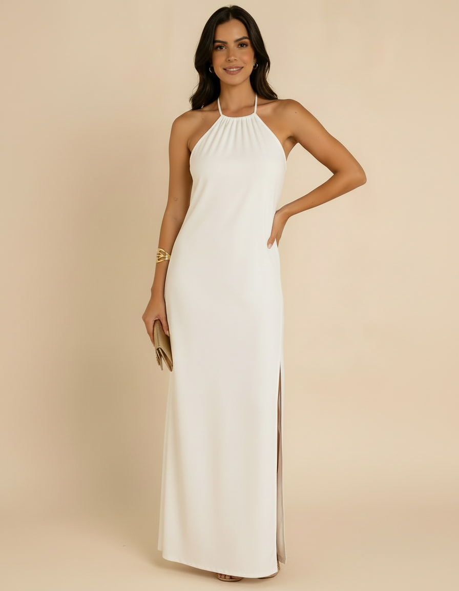 Modelo sorrindo com mão na cintura e clutch dourada usando vestido longo off-white com gola halter - Amarine