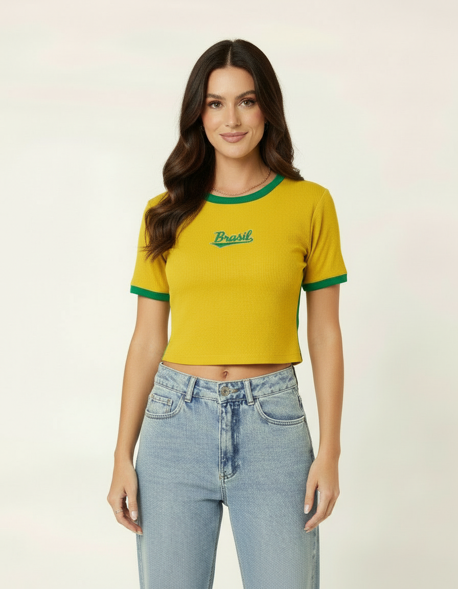 Mulher usando blusa cropped amarela com detalhes verdes estilo Brasil e calça jeans clara