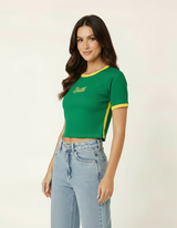 Mulher usando blusa cropped verde com detalhes amarelos estilo Brasil e calça jeans wide leg