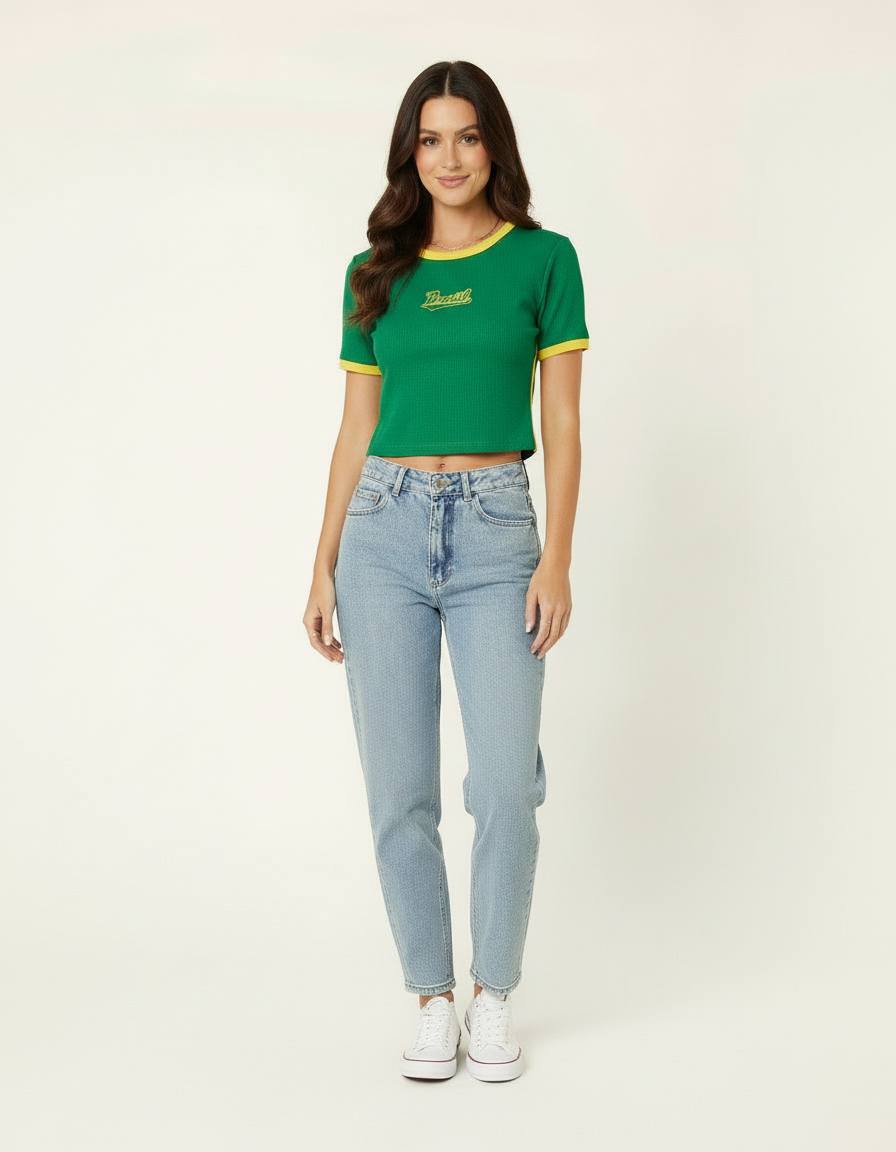 Mulher de corpo inteiro com blusa cropped verde estilo Brasil, calça jeans clara e tênis branco
