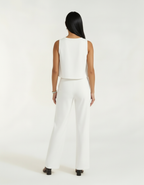 Mulher de costas com conjunto branco de blusa cropped e calça wide leg em detalhe