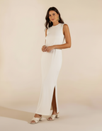 Mulher com vestido longo branco com fenda lateral e sandália branca de salto