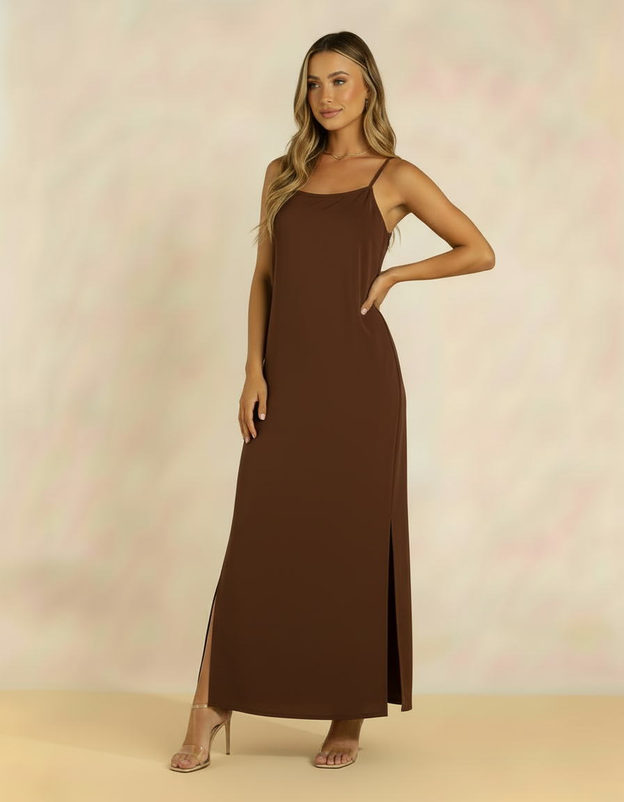 Mulher com vestido longo marrom de alças finas com fenda lateral e salto transparente
